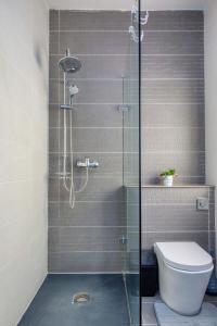 a shower stall with a toilet in a bathroom at The Apateu in St Paul's Bay