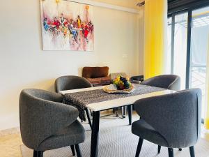 a dining room with a table and chairs at Silver Homes 2 bedroom nt in Kampala