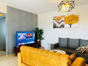 a living room with a couch and a television at Silver Homes 2 bedroom nt in Kampala