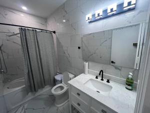 Un baño con lavabo, inodoro y espejo. en B12 Private Room In Cambridge, en Cambridge