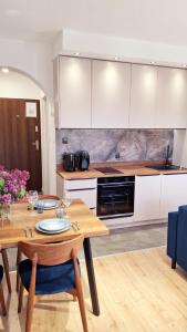 a kitchen with a wooden table with wine glasses on it at Rumia Cichy Zaułek 2 in Rumia +9 photos