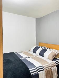 a bedroom with a bed with a striped blanket at Room Airport in Bogotá +22 photos