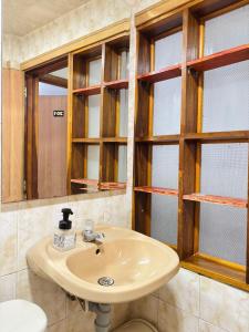 a bathroom with a sink and some windows at Room Airport in Bogotá