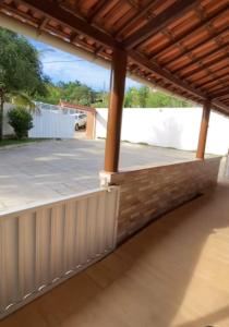 eine Terrasse mit Holzdach und ein Parkplatz in der Unterkunft Granja ao lado da festa Soul João in Lagoa Sêca