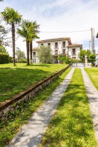 ein Gehweg vor einem Haus mit Palmen in der Unterkunft Casa Lago in Bellagio in Bellagio