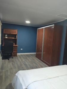 a bedroom with a bed and a desk and a chair at Kaike in Caleta Olivia