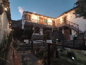 a house with a staircase leading up to it at Lodge Wayra Wasi in Coporaque