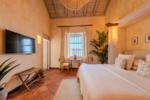a bedroom with a bed and a flat screen tv at Moet Cartagena Hotel Boutique Adutls Only in Cartagena de Indias