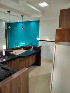 a kitchen with a sink and a blue wall at Apartamento charmoso in Pirassununga