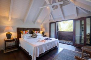 a bedroom with a bed and a large window at Te Vakaroa Villas in Rarotonga