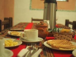 a table with plates of food and a cup of coffee at Lodge Wayra Wasi in Coporaque