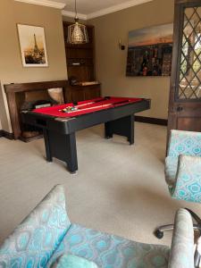 a ping pong table in a living room with a couch at Greenacres Hall in Disley