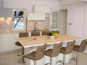 a kitchen with a table with chairs and a bowl of fruit on it at Villa Gabriel - Three Bedroom Villa with Outdoor Pool in Drniš