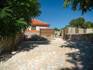 a house with a fence and a stone driveway at Villa Gabriel - Three Bedroom Villa with Outdoor Pool in Drniš