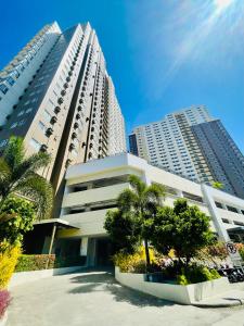 a large apartment building with trees in front of it at Spacious Stylish Studio Unit at Avida Aspira Tower 1 in Cagayan de Oro