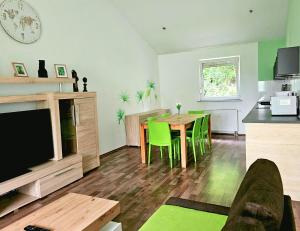 Una sala de estar con una mesa y sillas verdes. en City-Apartment, en Sinsheim