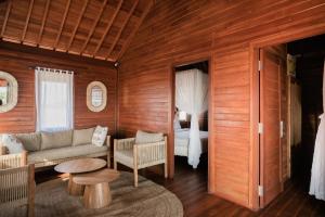 a living room with a couch and a table and a bed at Villa Hestia in Memboro