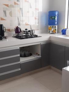 eine Küche mit einer Arbeitsplatte und einem Herd in der Unterkunft Privacidade para sua família e grupos em um só lugar-2 quartos- melhor custo-benefício, garagem, sala com cozinha integrada, aconchegante, ambiente moderno e funcional, wi-fi veloz gratuito, próximo ao Parque das Águas-Calçadão e tudo que a cidade oferece in São Lourenço