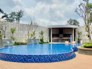 une grande piscine avec des carreaux bleus devant un immeuble dans l'établissement Karenina Agung Resort Semarang, à Gunungpati
