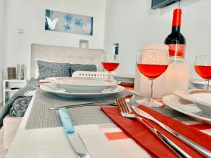 a table with glasses of red wine and a table cloth at Chora Suite in Mikonos