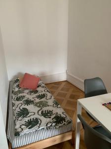 Ce lit se trouve dans un dortoir doté d'une table et d'une chaise. dans l'établissement Cosy and functional apartment close to Cornavin, à Genève