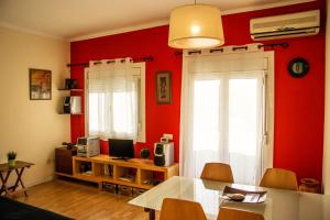 sala de estar con paredes rojas, mesa y sillas en A Home in Barcelona, en Barcelona