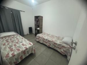 a bedroom with two beds and a book shelf at Tu lugar en Trenque in Trenque Lauquen