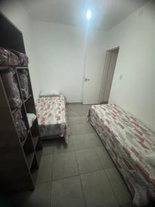 a room with two beds and a door to a bedroom at Tu lugar en Trenque in Trenque Lauquen +6 photos
