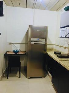 a stainless steel refrigerator in a kitchen with a table at Loft-Expo Norte-Brás-Anhembi in São Paulo +3 photos