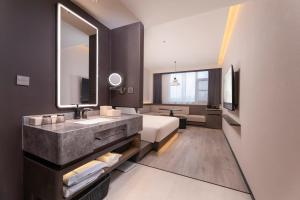 a bathroom with a sink and a bed in a room at Atour Hotel Suzhou Gusu Dongzhong in Suzhou +49 photos