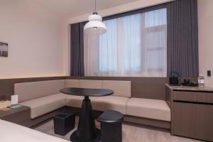 a living room with a couch and a table at Atour Hotel Suzhou Gusu Dongzhong in Suzhou