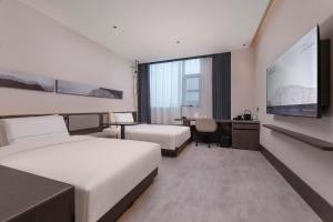 a hotel room with two beds and a flat screen tv at Atour Hotel Suzhou Gusu Dongzhong in Suzhou