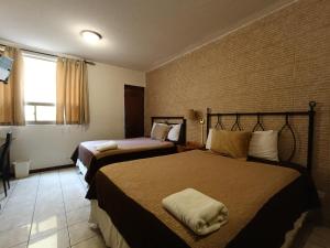 a hotel room with two beds and a window at Hotel Casa Blanca Inn in Estación Pamplona