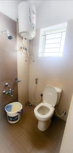 a bathroom with a toilet and a sink and a window at Maria villa in Ooty +2 photos