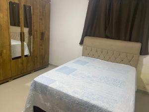 a bedroom with a bed and a wooden cabinet at Casa mar in Maragogi
