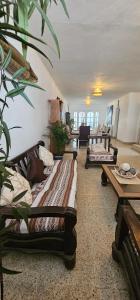 a living room with several couches and tables at Yellow Surf House in Huanchaco