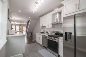 フィラデルフィアにあるHome in Philadelphia Stadium nearbyの白いキャビネットとコンロ付きオーブンを備えたキッチン