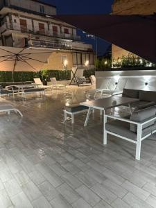 a patio with white tables and chairs and a building at Palazzo Valentino in Naples