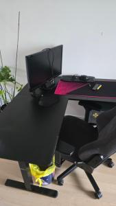 una scrivania nera con monitor per computer e sedia di 120n Villa Hietala paritalo, 1-8henkilön LUXUS majoitus, 3x160cm jenkkisängyt Löhösohvat, iso takaterassi, täyd keittiö Kodink, laatu sauna, Takka, Tv 75" x2, 2wc, autokatos, avainboxi koodilla, itsekirjaus 24h, wifi ja 500mb kuitunetti, kuivaava pesukone a Seinäjoki Altre 23 foto