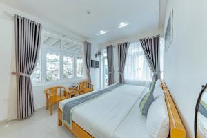 a bedroom with a bed and a window at Ngân Hà Xanh Hotel in Da Lat