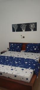 a bedroom with a bed with blue sheets and stars at Maleh Plus in Kribi