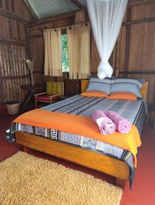 Bella Victoria Ecolodge في Santa María: غرفة نوم بها سرير عليه منشفتان