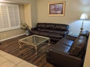 a living room with a leather couch and a coffee table at Beautiful Large Residential Home in Layton