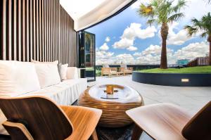 a patio with a couch and a table and palm trees at Magical Sunset SkyView BEST location in Brisbane in Brisbane