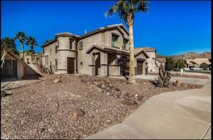a large house with a palm tree in front of it at The Reserve Large Home and Pool in Phoenix