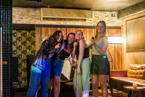 a group of girls standing in a room with microphones at Aquarius Backpackers Resort in Byron Bay +87 photos