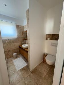 a bathroom with a toilet and a sink at Le Christina in Saint-Paul +26 photos