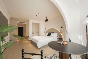 a hotel room with a bed and a table at Town Designer B&B in Qingdao