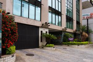 un edificio con una puerta negra y flores rojas en Te Adoro Hotel (Adult Only), en Río de Janeiro