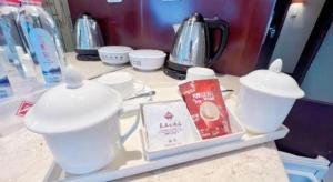 a counter top with white cups and a tea pot at Chang An Hotel in Shenzhen